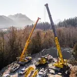 Thumbnail of Omega Morgan's two yellow Cranes with extended booms with mountains in the background.
